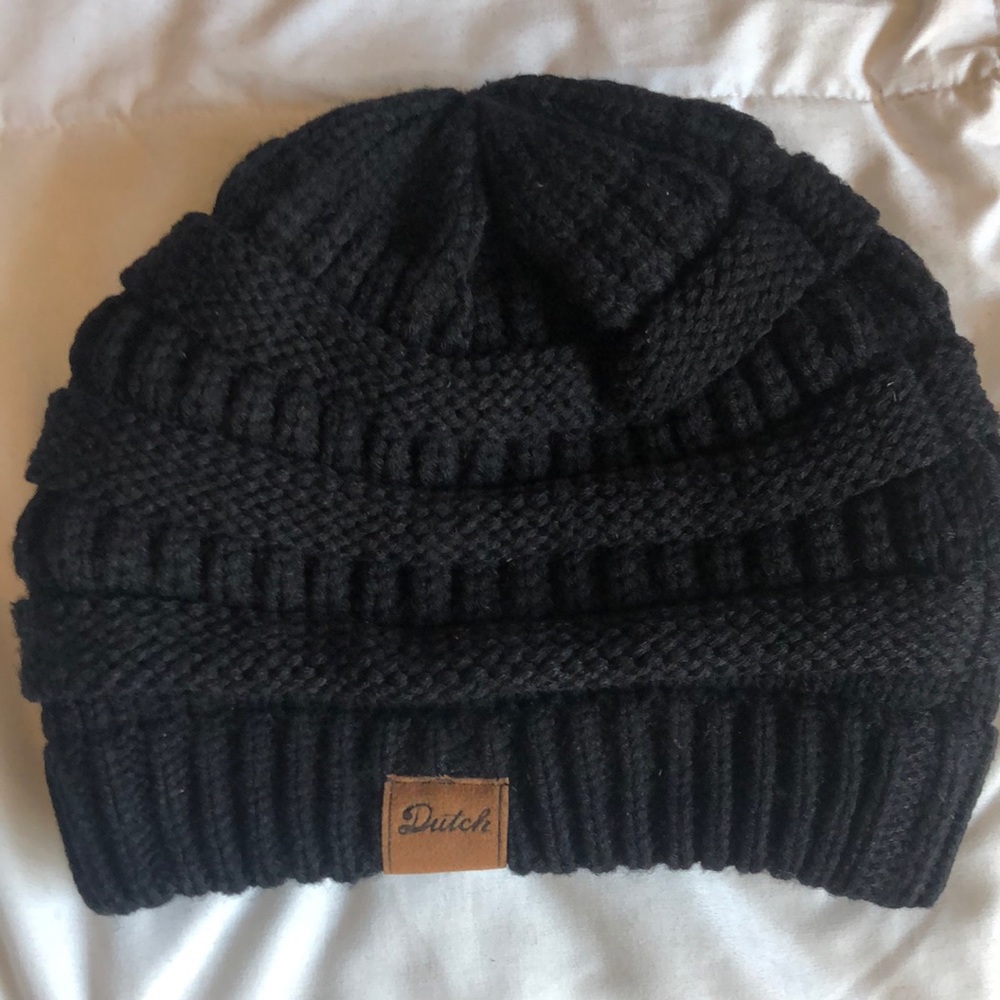 Dutch Bros black crocheted beanie with brown leather logo tag on front